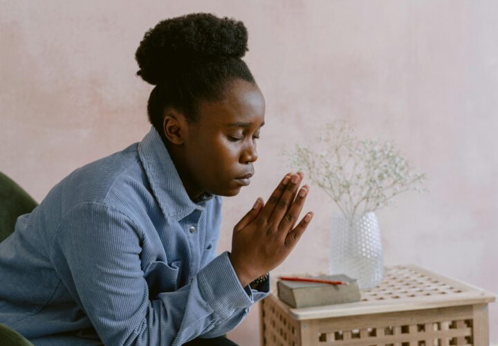 Serene image of a woman with eyes closed in prayer, symbolizing faith and devotion.
