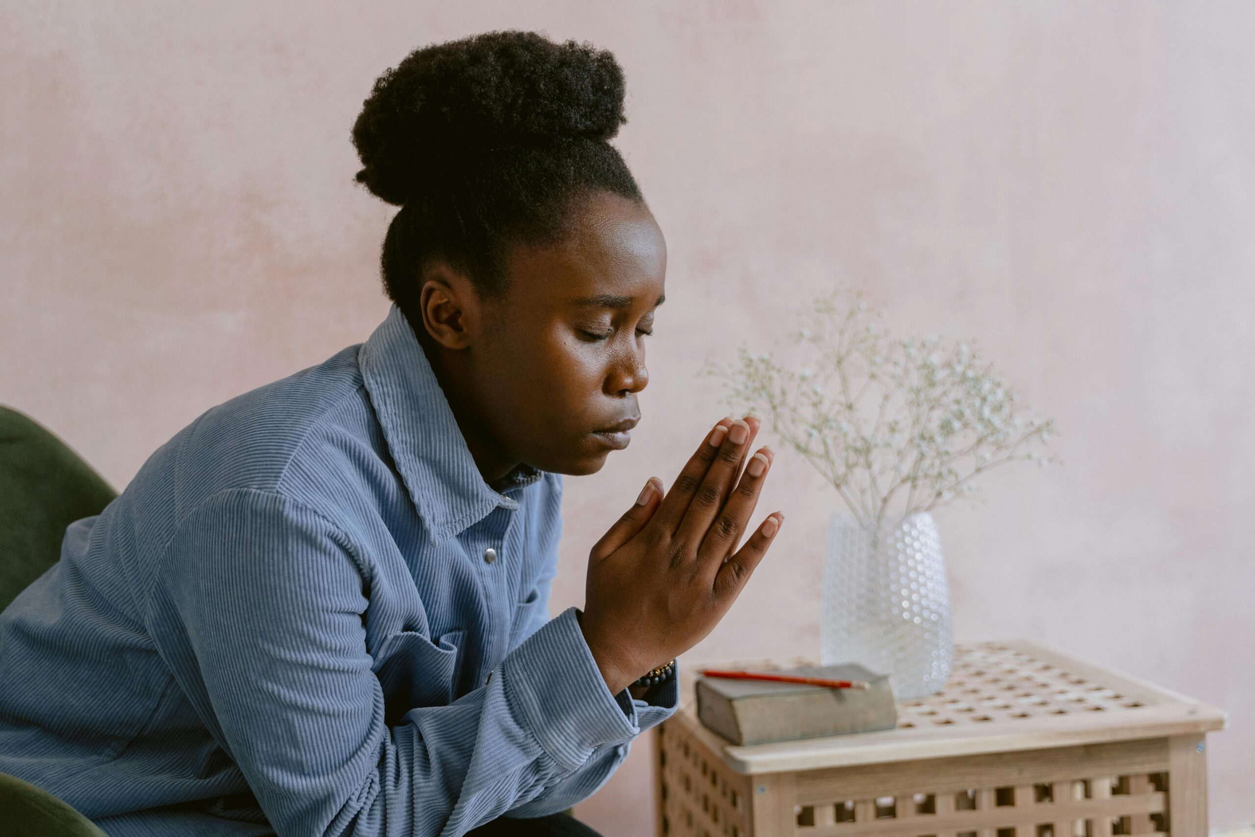 Serene image of a woman with eyes closed in prayer, symbolizing faith and devotion.